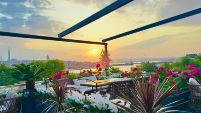 a patio with flowers and a sunset in the background at Gzh Park Bosphorus in Istanbul