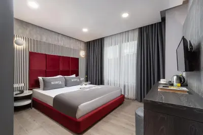 a bedroom with a large bed with a red headboard at Siesta Hotel Bakırköy in Istanbul