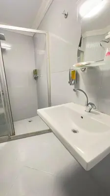 a white bathroom with a sink and a shower at New Hotel Harbiye in Istanbul