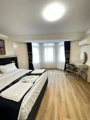 a bedroom with a large bed and a desk at New Hotel Harbiye Studio in Istanbul