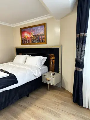 a bedroom with a bed and a painting on the wall at New Hotel Harbiye Studio in Istanbul