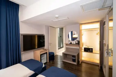 a hotel room with a bed and a flat screen tv at Querencia Hotel in Istanbul