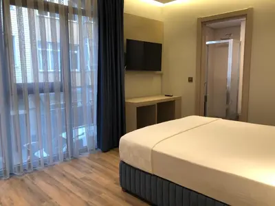 a bedroom with a bed and a flat screen tv at The Palm Bosphorus Hotel in Istanbul