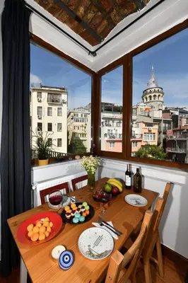 a dining room table with a view of a city at Taksim-Galata Tower Is Almost In Your Bedroom And In The Balconies Rooftop Terrace with Golden Horn View in Istanbul