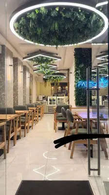 a restaurant with wooden tables and chairs and plants at Fabesco Suite in Istanbul