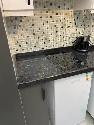 a kitchen with a counter top and a tile wall at Fabesco Suite in Istanbul