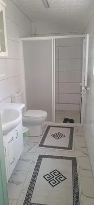a bathroom with a shower and a toilet and rug at Town center house in İznik
