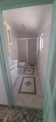 a white bathroom with a toilet and a sink at Town center house in İznik