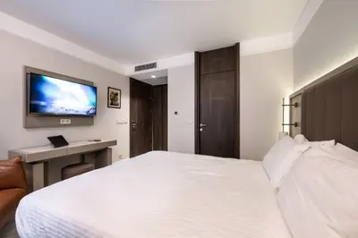 a bedroom with a white bed and a tv on the wall at Noble Pangaltı in Istanbul