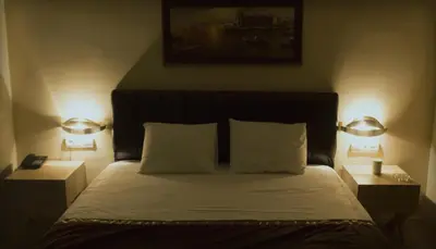 a bedroom with a bed with two lights on it at Sun Suites in Istanbul