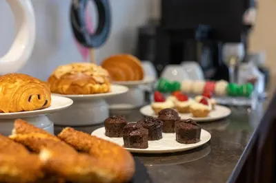 a bunch of different types of pastries on plates on a counter at Ess Hotel in Istanbul