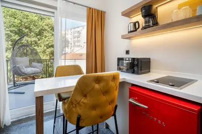 a kitchen with a counter and chairs and a window at Urban Quarters - Boğazkesen in Istanbul