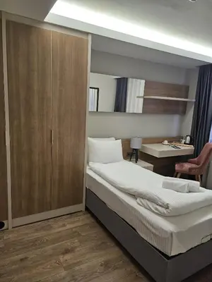 a bedroom with a large bed and a desk at Frezya Family Hotel in Istanbul