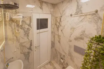 a bathroom with a toilet and a shower with marble walls at Ozer Hotel & Apartments in Istanbul