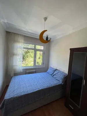 a bedroom with a blue bed and a window at Acıbadem Kadıköy Daire in Istanbul