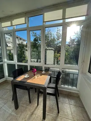 a table and chairs in a room with large windows at Acıbadem Kadıköy Daire in Istanbul