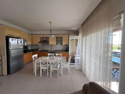a kitchen and dining room with a white table and chairs at Aktaş Gümüşyaka Villaları in Silivri