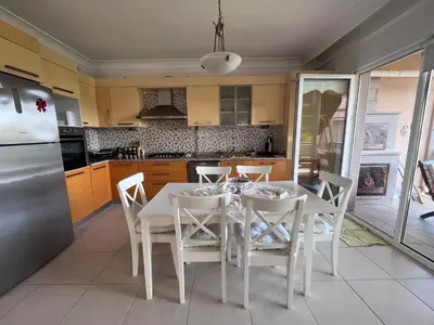 a kitchen with a white table and chairs and a refrigerator at Aktaş Gümüşyaka Villaları in Silivri