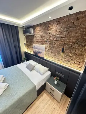 a bedroom with a bed and a brick wall at Sea Sparkle in Istanbul