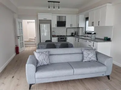 a living room with a couch and a kitchen at Orkide Sapanca in Sapanca