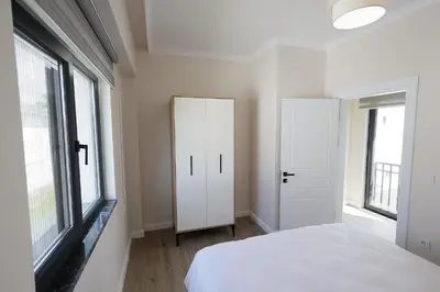 a bedroom with a white bed and two windows at Orkide Sapanca in Sapanca