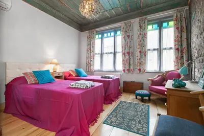 a room with two beds and a couch and windows at Turquoise House Featured in Elle Decor Magazine in Istanbul