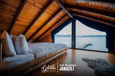 a bedroom with a bed with a view of the water at Sapanca Göldibi Suit Bungalov in Sakarya