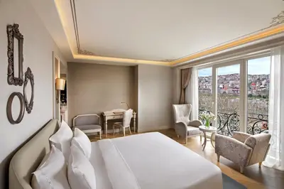 a bedroom with a white bed and a table and chairs at Lazzoni Hotel in Istanbul
