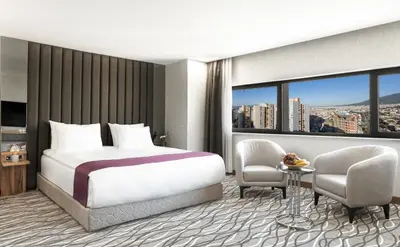 a hotel room with a bed and a table and chairs at Lilium Hotel & Suites in Bursa