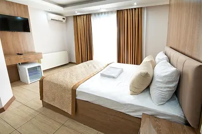 a hotel room with a bed and a television at Lion City Hotel in Buyukcekmece
