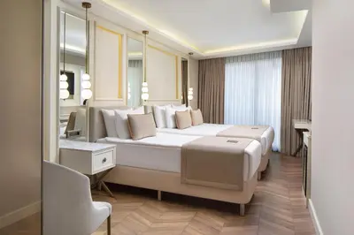 a bedroom with a large white bed and a mirror at Great Fortune Concept Hotel in Istanbul