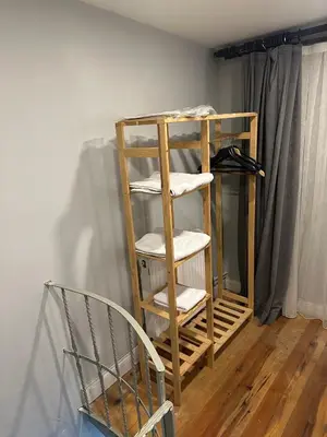 a wooden shelf with white towels on it next to a chair at Moon suit in Istanbul