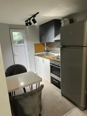 a kitchen with a stainless steel refrigerator and a table at Moon suit in Istanbul