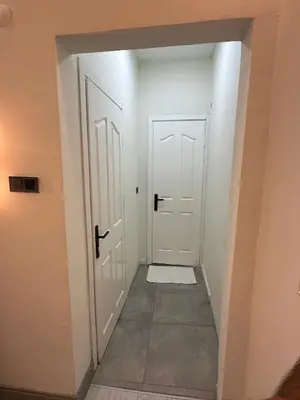a hallway with two white doors and a tile floor at Moon suit in Istanbul