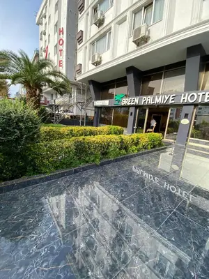 a glass table in front of a hotel at Green Palmiye Hotel in Avcılar