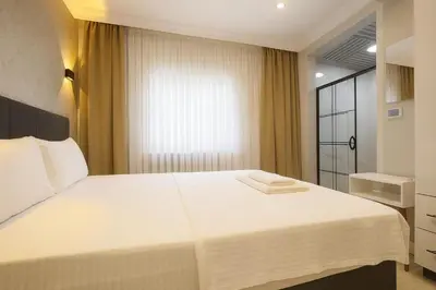 a bedroom with a large white bed and a window at Casa Florya Suites in Istanbul