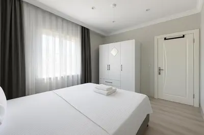 a white bedroom with a white bed and a window at Casa Florya Suites in Istanbul