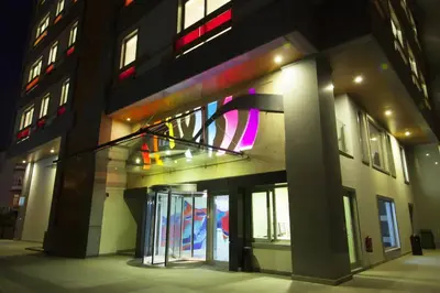 a building with a glass entryway with a neon sign at The Leos Residence in Istanbul