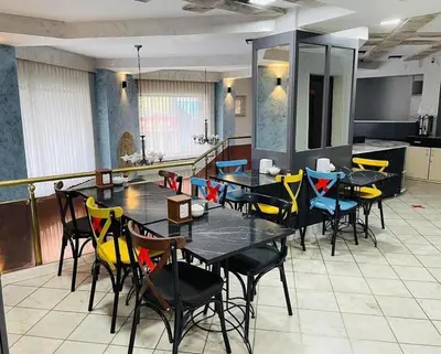 a dining room with black tables and yellow chairs at Hotel Oz Villa in Istanbul
