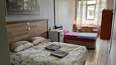 a small bedroom with two beds and a table at Çiğdem Motel Pansiyon & PUB in Termal