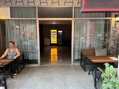 a woman sitting at a table in a restaurant at Çiğdem Motel Pansiyon & PUB in Termal