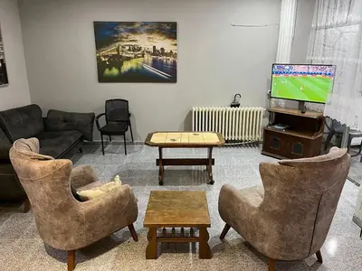 a living room with couches and a flat screen tv at Çiğdem Motel Pansiyon & PUB in Termal
