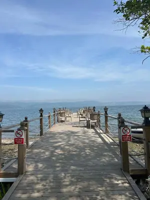 a wooden boardwalk leading to the ocean on a beach at Kalimeras Deluxe Hotel in Sapanca