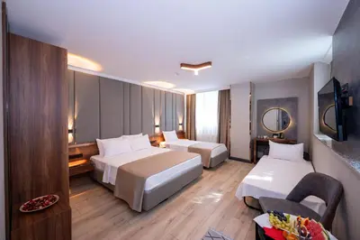 a hotel room with two beds and a chair at Vess Hotel in Istanbul