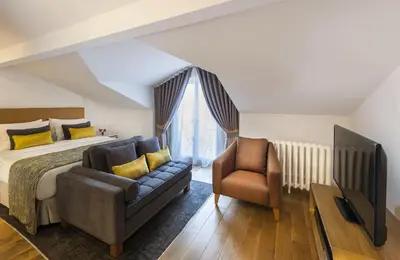 a bedroom with a bed and a couch and a chair at Nevv Bosphorus Hotel & Suites in Istanbul