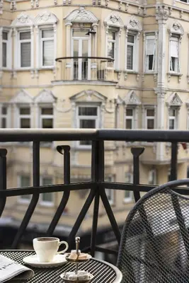 a cup of coffee sitting on a table on a balcony at Nevv Bosphorus Hotel & Suites in Istanbul