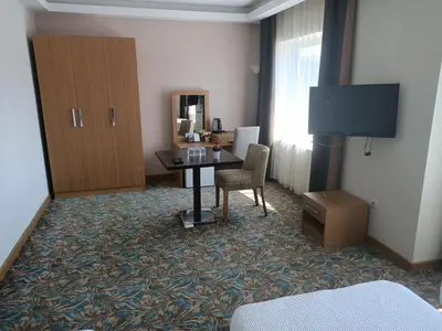 a hotel room with a desk and a table with a chair at Helenapolis Otel in Yalova
