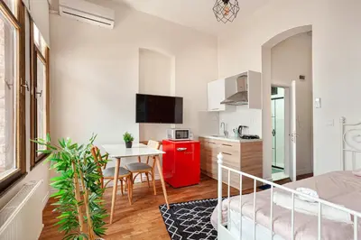a white kitchen with a red refrigerator and a table at Armel Homes Taksim in Istanbul