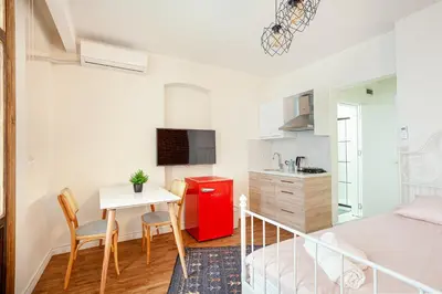 a bedroom with a small table and a red refrigerator at Armel Homes Taksim in Istanbul