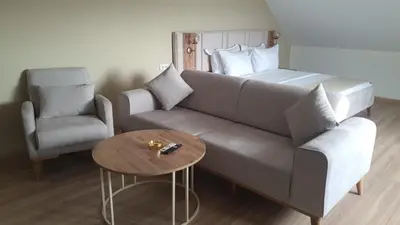 a living room with a couch and a chair and a table at Petra Port Hotel in Tuzla